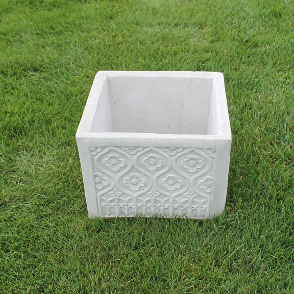 A large square planter with lattice like flowered design on all sides