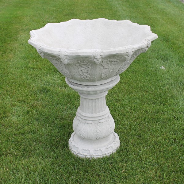 A two piece planter set with a detailed design on the bowl and base. 