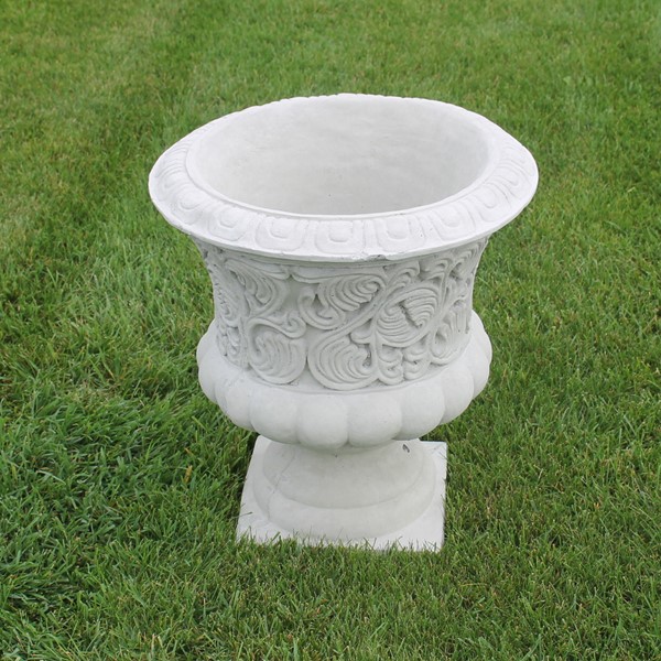 A scroll decorative planter with a fancy design along the exterior.