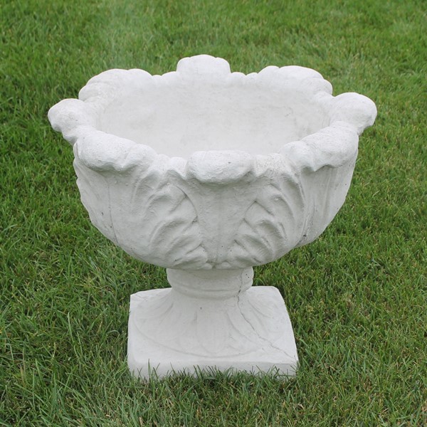 A planter with a square base and a round bowl with a decorative tobacco leaf design.