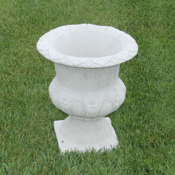 An urn styled planter with decorative flowers in the details. 