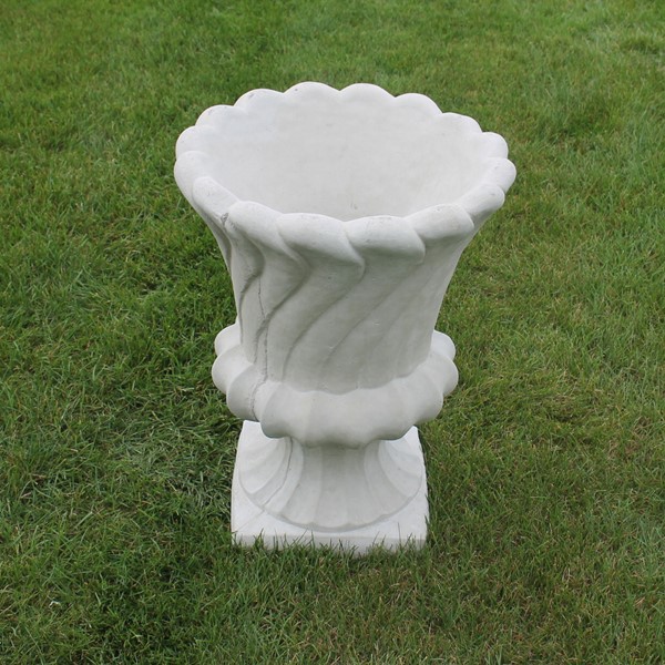 A urn style planter with a wave like, or gentle curve design to the exterior 